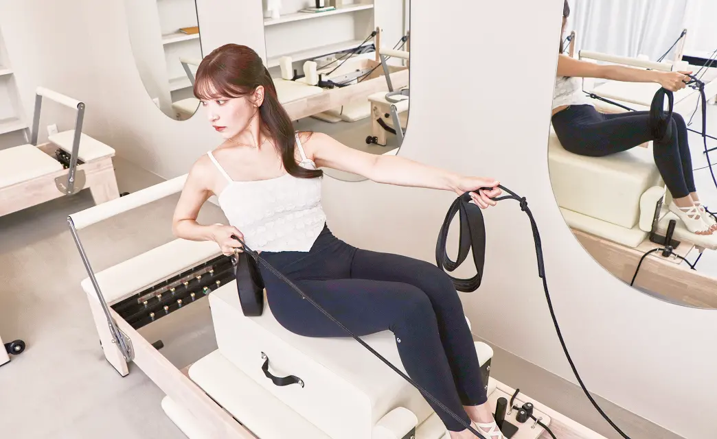 ピラティスマシンで女性がストレッチをしている様子